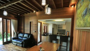 Un interior de madera con sofá, mesa de comedor y zona de cocina.