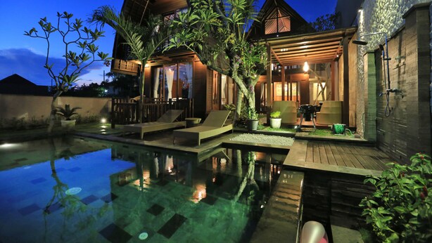 Una villa moderna con piscina, zonas de estar y terraza cubierta.