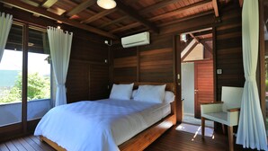 Dormitorio de cabaña de madera con cama, una silla y un equipo de aire acondicionado.
