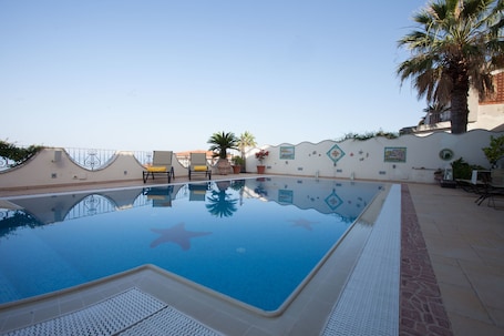 Una piscina al aire libre de temporada, sillones reclinables de piscina