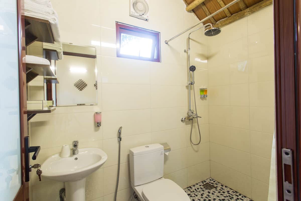 A small bathroom with a sink, toilet, and shower.