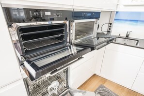 Apartamento Deluxe, 2 habitaciones | Cocina privada | Frigorífico grande, microondas, horno y placa de cocina