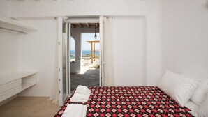 Een slaapkamer met een bed, een witte bank en uitzicht op de omgeving.