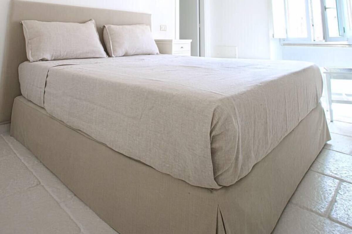 Une chambre spacieuse avec un grand lit, un dressing et une vue sur l’extérieur.
