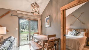 A cozy room with a wooden dining table, a sofa, and a bed with a view of the outdoors. - Flying Dutchman 1174 (Keystone)