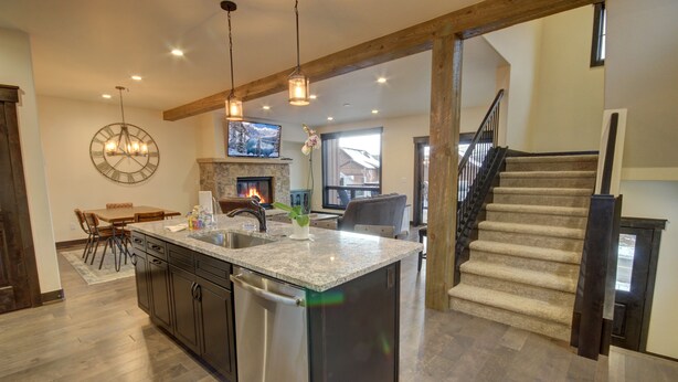 A spacious kitchen with a central island, built-in appliances, and a stone fireplace. - Alders 854 Independence Rd (Keystone)