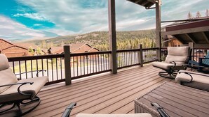 A wooden deck with outdoor seating, a view of a forested mountain range, and a clear sky. - Alders 854 Independence Rd (Keystone)