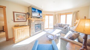 A living room with a fireplace, a television, and a sofa. - Red Hawk Lodge 2264 (Keystone)