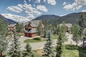 Un chalet doté d’un bâtiment principal entouré d’arbres, situé dans un cadre montagneux.