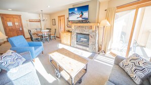 A living room with a fireplace, a television, and a dining area. - Red Hawk Lodge 2264 (Keystone)