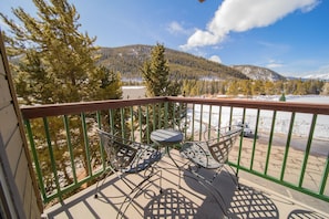 A balcony with a metal railing, two chairs, and a small table. - Lenawee 1728 (Keystone)