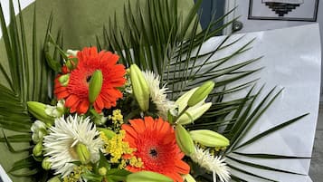 A bouquet of flowers with green leaves and a blue sign with the number 19 in the background.