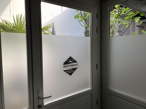 Una puerta con paneles de vidrio esmerilado y un adhesivo con logotipo.