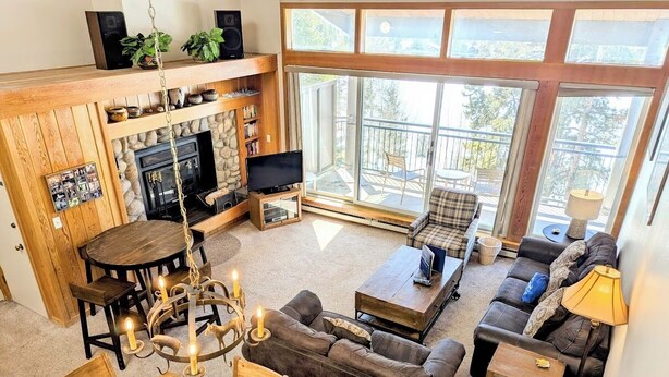 A cozy living room with a fireplace, a dining area, and a sofa set. - Pines 2169 (Keystone)