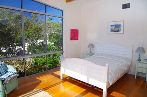 A bedroom with a large window, a bed, two bedside tables with lamps, and a chair. - Point Break, 14 Korogora Street, (Crescent Head)