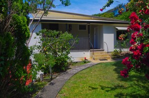 A single-story house with a front porch, a small garden, and a pathway leading to the entrance. - Rosemaree, 24 East Street, (Crescent Head)