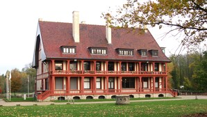Un grand bâtiment à deux étages, doté d’un toit en pente et de nombreuses fenêtres.