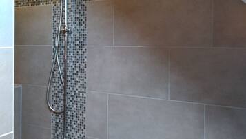 Een douche met een handdouche en een inbouw regenstortdouche.