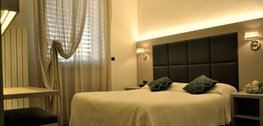 A hotel room with a bed, bedside tables, a lamp, and curtains. - Hotel Etruria (Forte dei Marmi)