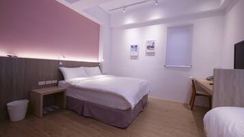 A modern bedroom with a bed, bedside table, and a desk.