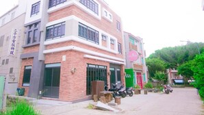 Un edificio de varios pisos con letrero de Missy Inn, fachada de ladrillo y entrada con portón.