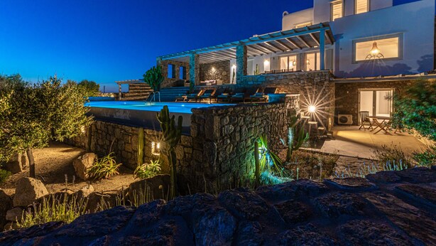 A modern villa with a pool, stone walls, and outdoor seating. - DreamLike Villas Mykonos (Mykonos)