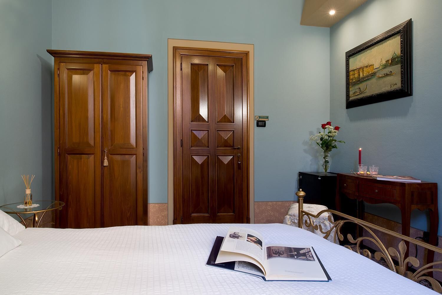 Une chambre à coucher comprenant un lit, une table de chevet, un bureau et deux portes en bois.