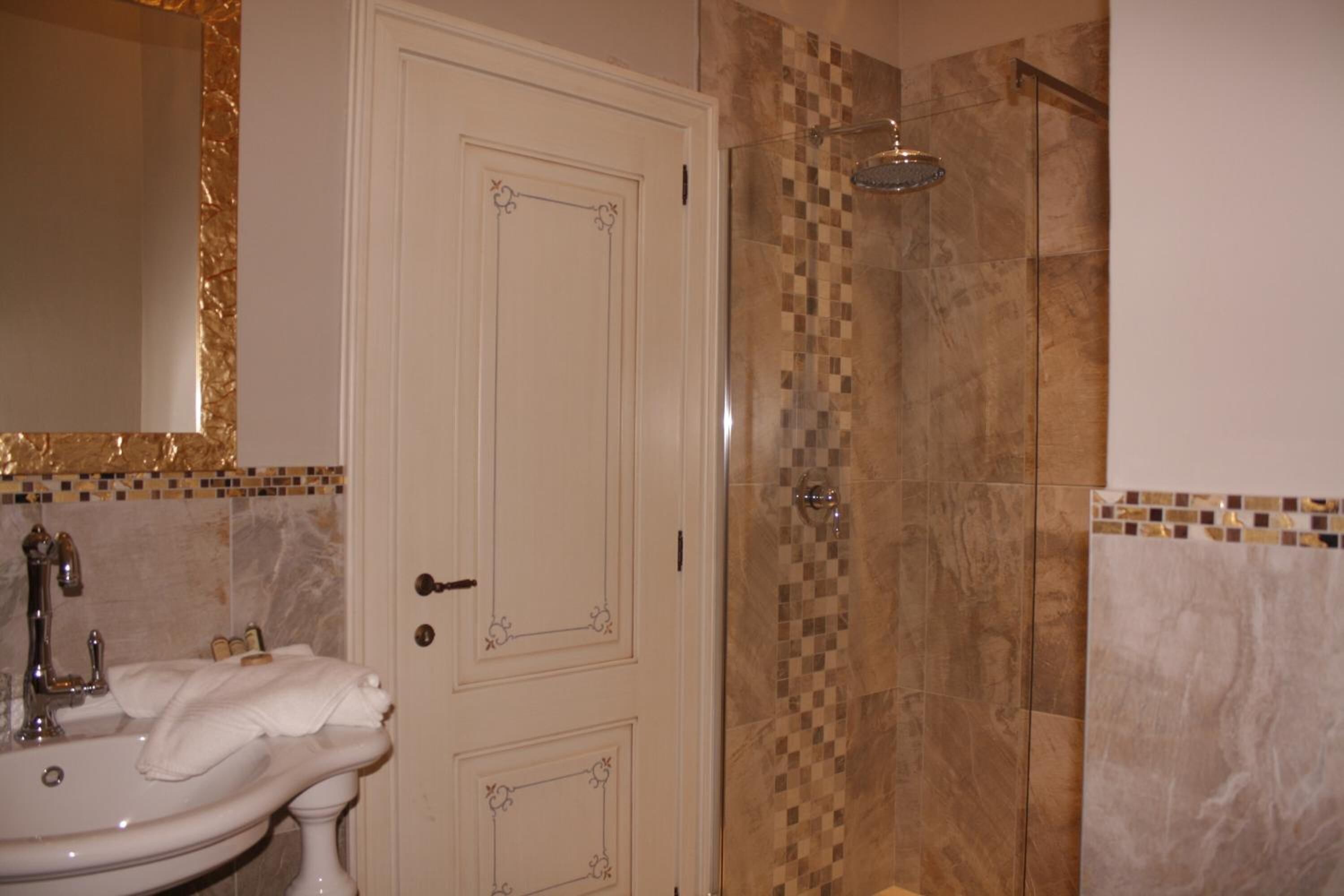 Un baño con lavamanos, espejo y ducha.