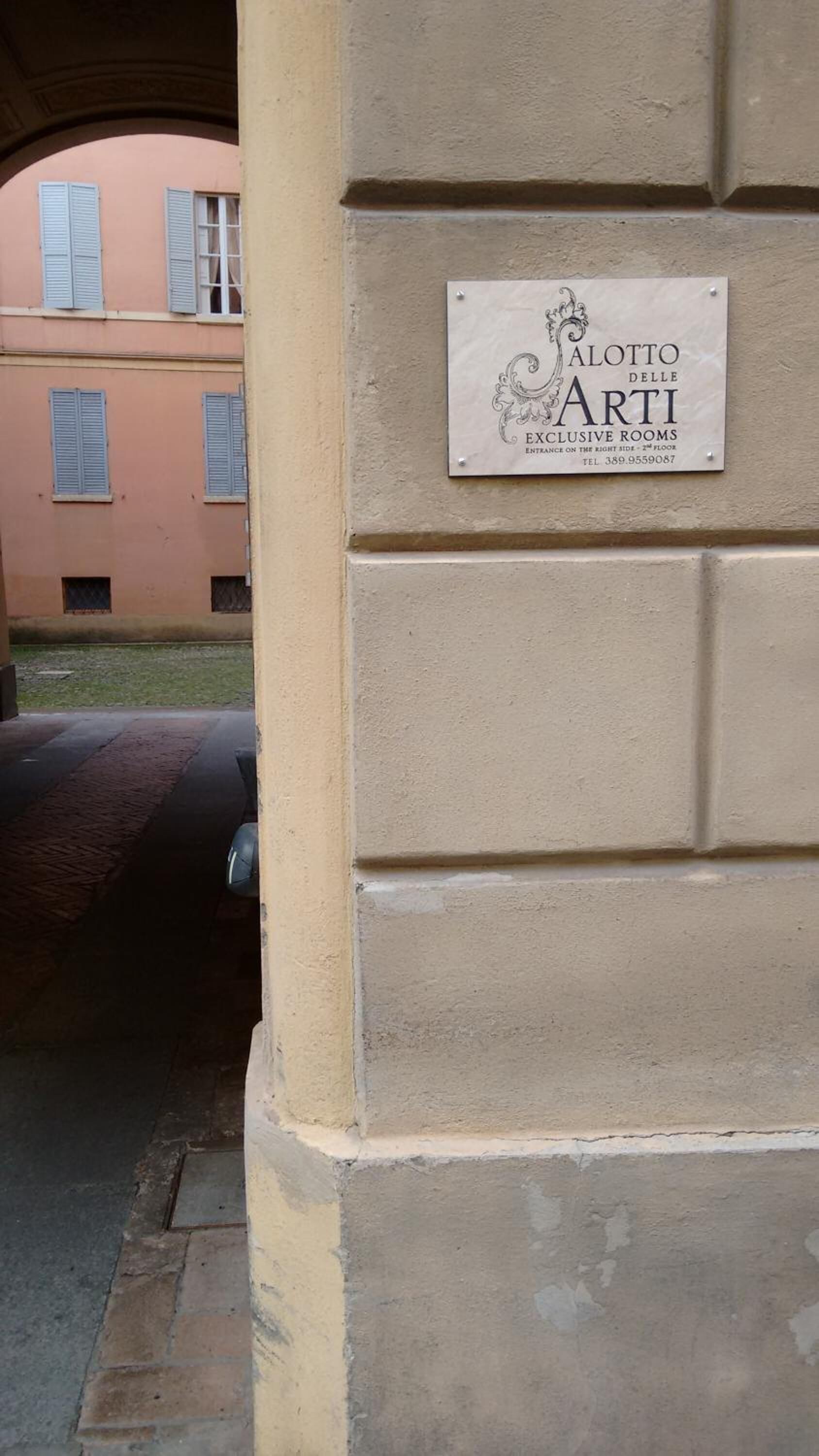 A sign for 'Alotto delle Arti' indicating exclusive rooms on the right side, 2nd floor.