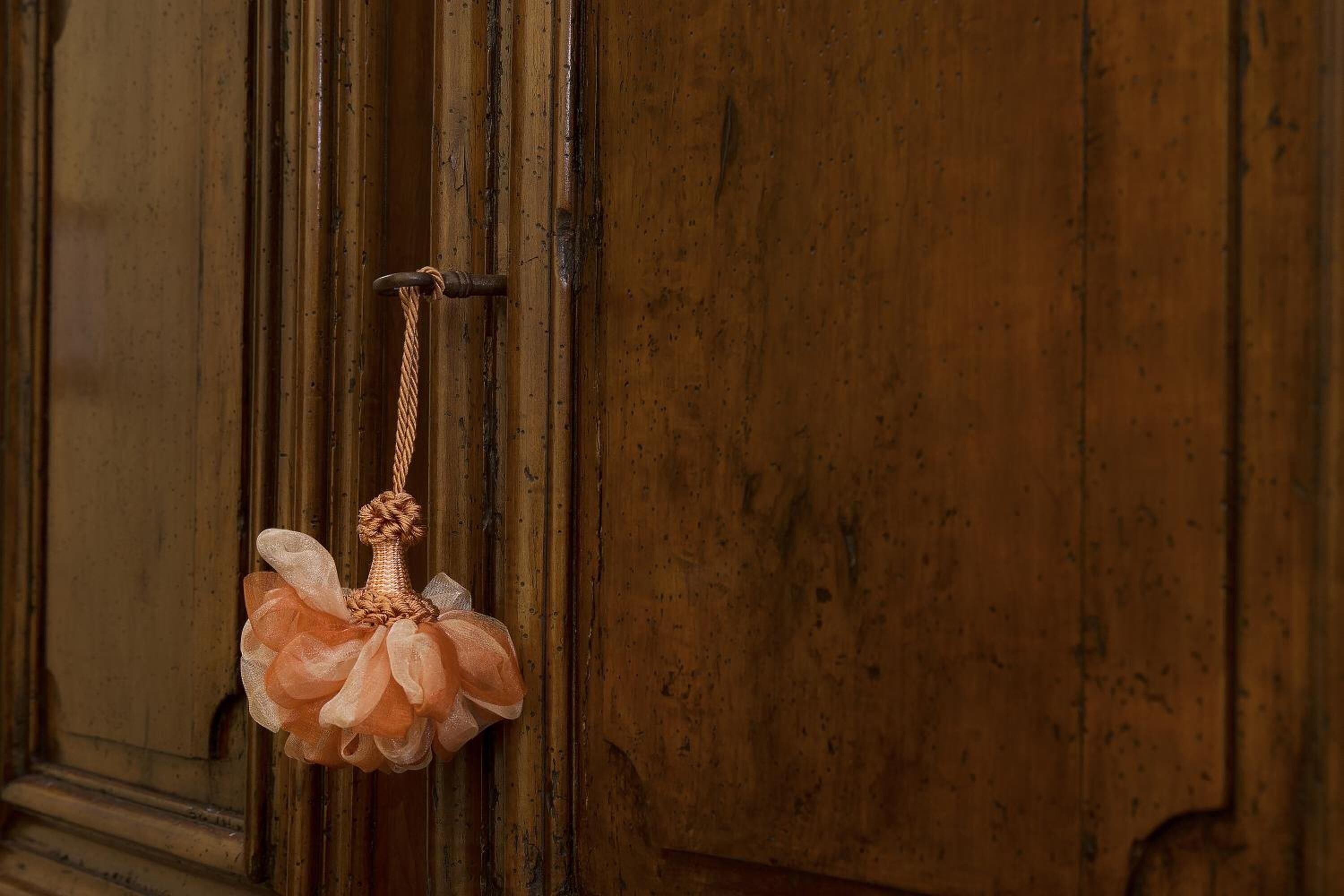 Une porte en bois, ornée d’une corde et d’un objet décoratif suspendu.