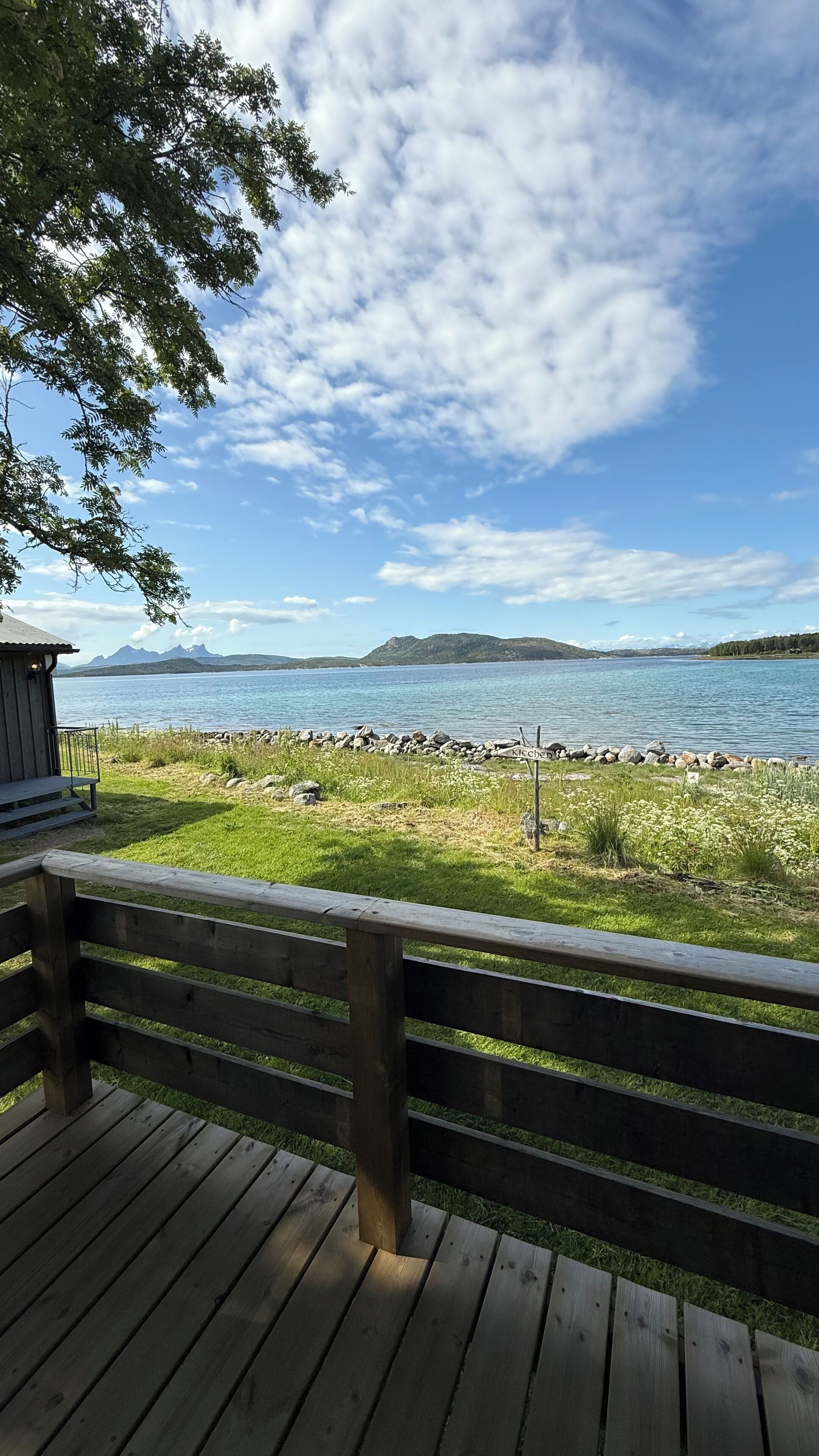 A wooden deck with a view of a lake and mountains.