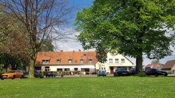 Een hotel in traditionele Europese stijl, met een rode dakbedekking en een bord.