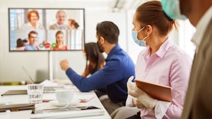 A conference room with a large screen displaying a video call. - Hotel Nierswalder Landhaus (Goch)
