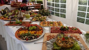 A buffet table with various food items and a large window in the background. - Hotel Nierswalder Landhaus (Goch)
