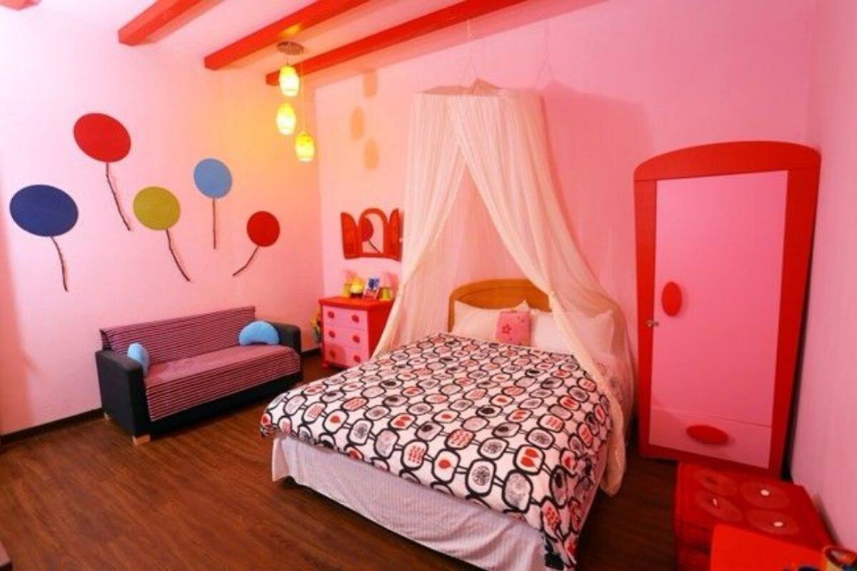 A bedroom with a bed, a bench, a wardrobe, and a bedside table.