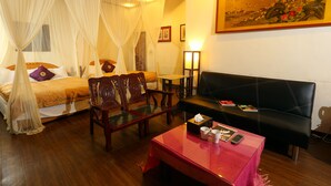 A room with a bed, a sofa, a coffee table, and a traditional chair. - Jiufen Jiudaokou B&B (New Taipei City)