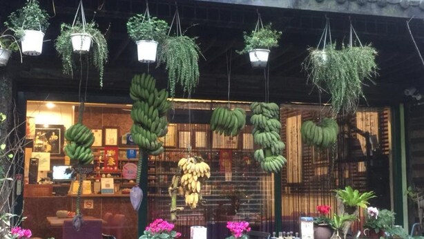 A storefront with hanging plants and a display of bananas. - Jiufen Jiudaokou B&B (New Taipei City)