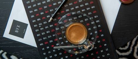 A calendar with a coffee cup and a pair of glasses on top.