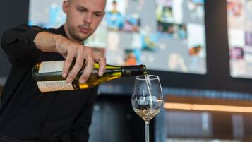Una persona sirviendo vino en una copa.