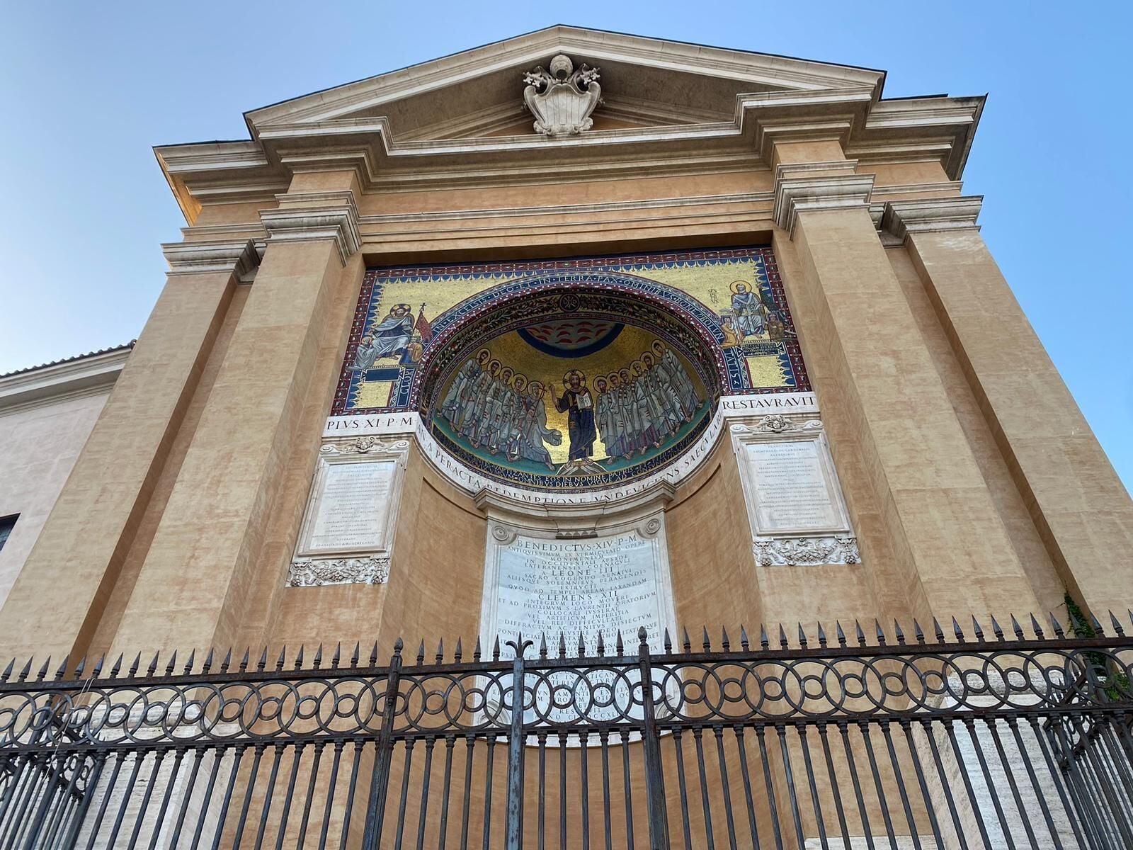 Un edificio histórico con un gran mosaico e inscripciones.