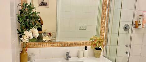Ein Badezimmer mit Waschbecken, Spiegel und Dusche.