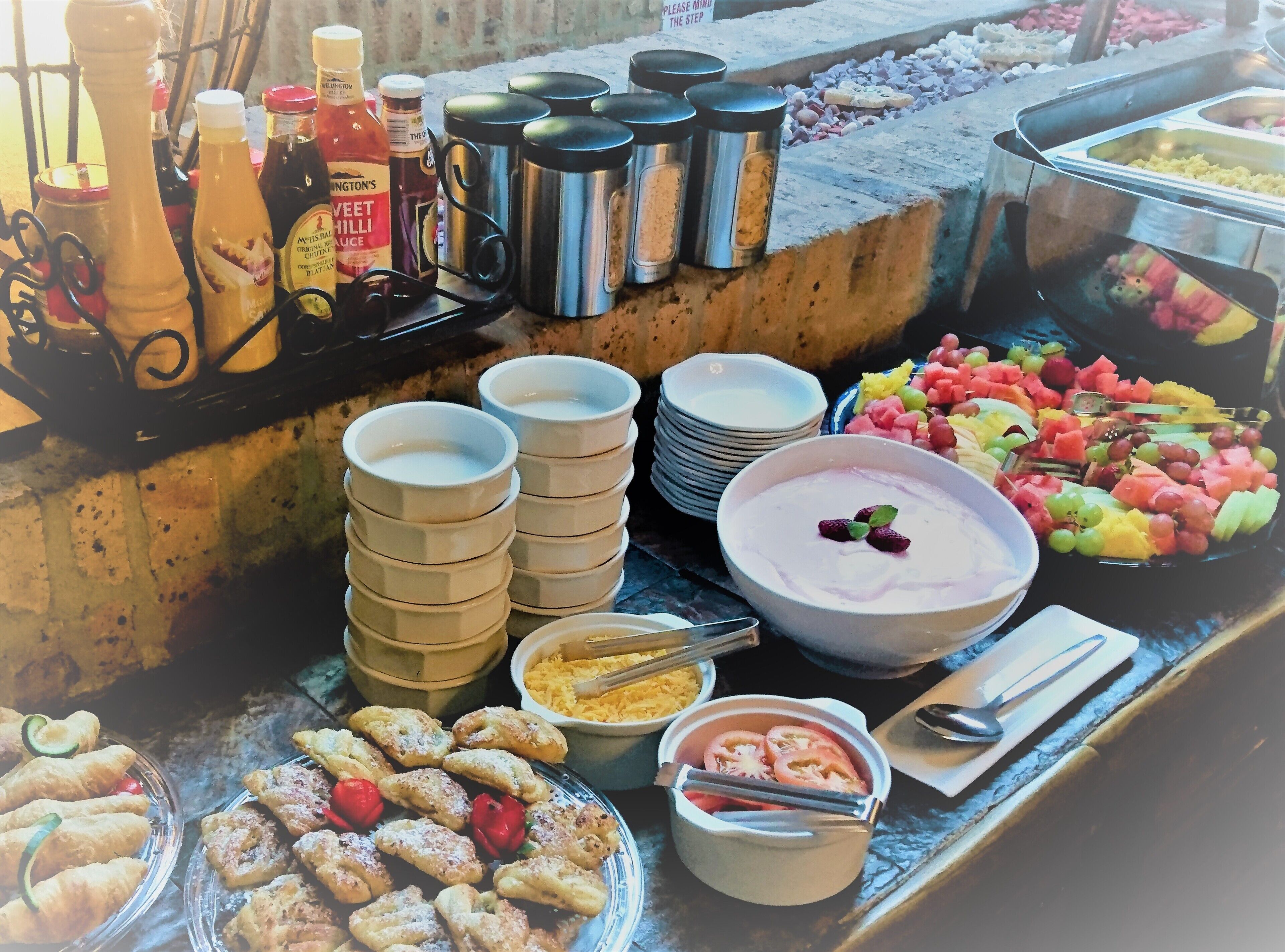 A buffet with various food items, condiments, and utensils.