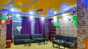 A living room with a sofa, two tables, and a decorative wall.