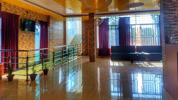 A spacious lobby with a polished floor, a staircase, and a seating area.