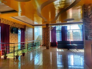 A spacious lobby with a polished floor, a staircase, and a seating area. - Hotel Merina Sreemangal (Sreemangal)