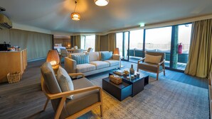 A spacious living area with a sofa, chairs, a coffee table, and a dining area.
