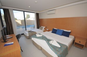 Habitación triple económica, vista a la alberca, planta baja | Minibar, caja de seguridad en la habitación y insonorización 