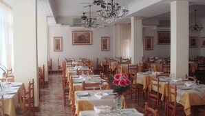 A dining area with multiple tables and chairs, arranged in rows.