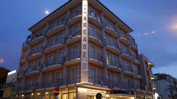 A multi-story hotel with balconies and a prominent vertical sign reading "ARCADE".