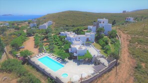 A coastal residential area with modern houses, a swimming pool, and a hilly landscape. - Villa Sofia (Andros)
